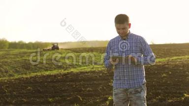 一位年轻漂亮的农民学生在田里<strong>干活</strong>，手里拿着拖拉机，手里拿着里面的肖像